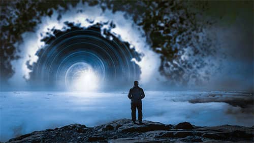 Silhouette d'un homme debout sur un rocher, face à un halo de lumière au-dessus d'une mer de nuages